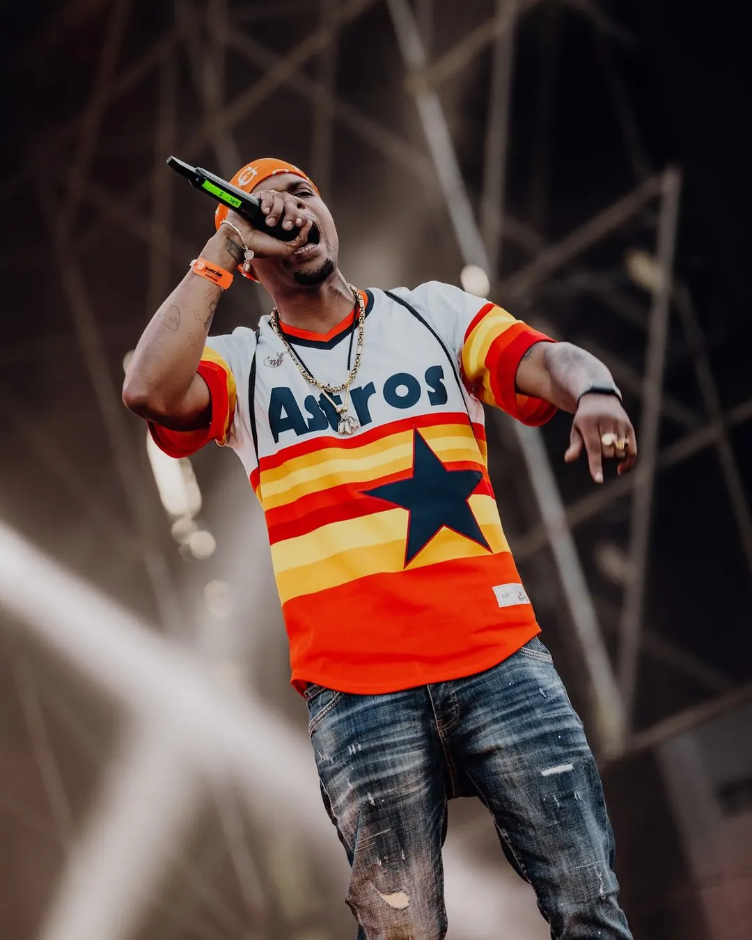 Rapper in oranje licht tijdens zijn set