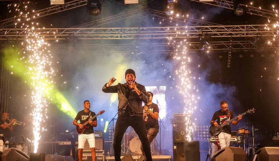 Zanger met band onder vonkenfonteinen op een Hardcore-podium
